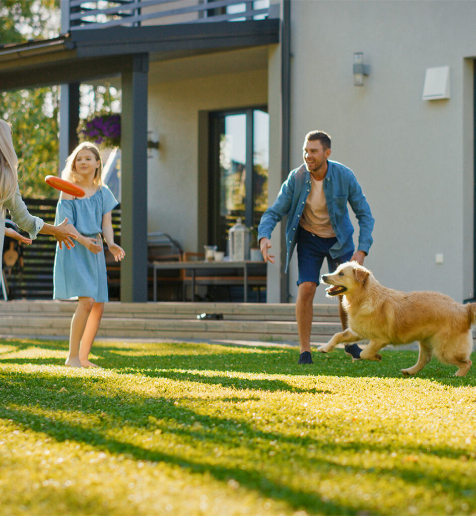 Family playing with their golden retriever on a freshly cleaned lawn after professional dog poop cleanup service in Harrisburg, PA